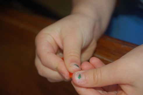 preschooler hands threading a bead